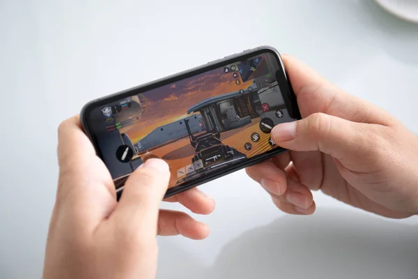 Hombre de la mano celebración de iPhone 11 juego Call of Duty móvil —  Fotos de Stock