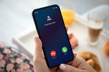 Kadın elleri ekranda gelen arama ile birlikte telefonu tutuyor.