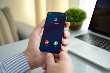 Erkek eli ekranda gelen arama ile telefonu tutuyor.