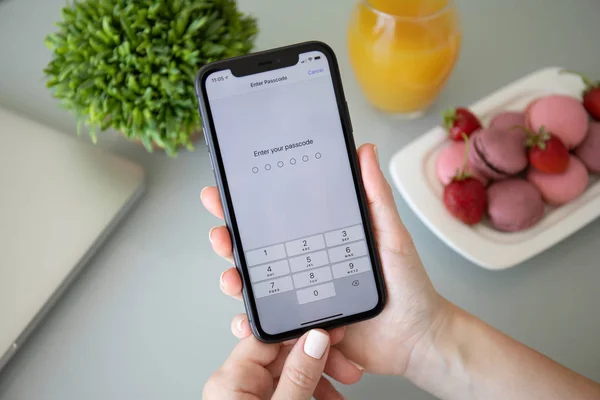 Frau hält iPhone 11 mit PIN-Code auf dem Bildschirm — Stockfoto