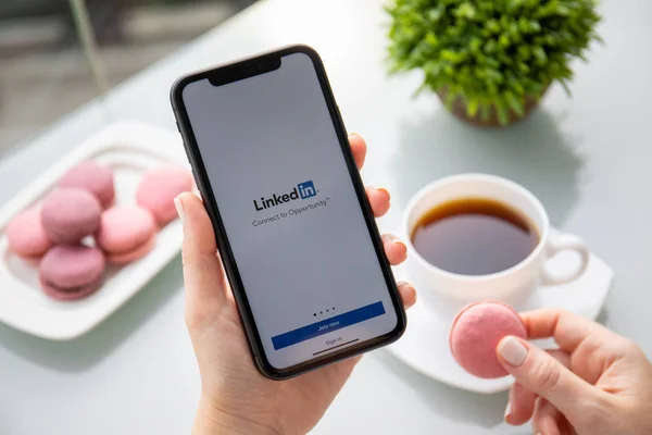 Γυναίκα χέρι κρατώντας iphone 11 με εφαρμογή Linkedin στην οθόνη — Φωτογραφία Αρχείου