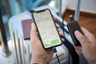 Alanya, Türkiye - 23 Mayıs 2020: Powerbank RavPower ve iPhone 11 'i ekranda uygulama pili ile elinde tutan adam