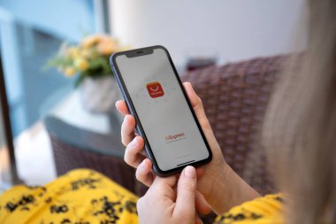 Alanya, Türkiye - 6 Haziran 2020: İnternet alışveriş servisi Aliexpress ile iPhone 11 'i tutan kadın ekranda görülüyor. iPhone Apple tarafından oluşturuldu ve geliştirildi..