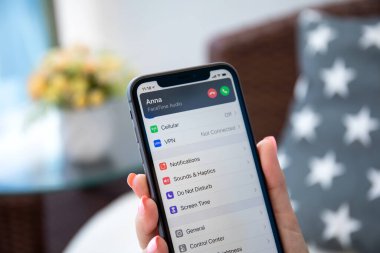 Alanya, Türkiye - 9 Ağustos 2020: Kadın, iPhone 11 IOS 14 ile ana ekranda telefon dinleme aygıtı ile el ele tutuşuyor. iPhone 11 Apple tarafından oluşturuldu ve geliştirildi.