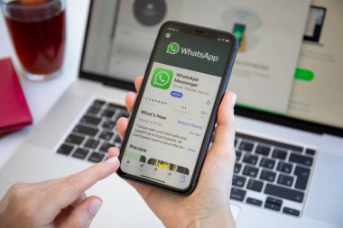 Alanya, Türkiye - 6 Haziran 2020: iPhone 11 ve Macbook Pro 16 'yı elinde tutan kadın haberci WhatsApp ile ekranda.