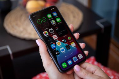 Alanya, Türkiye - 10 Temmuz 2020: Ekranda telefon gereçleri ev yapımı IOS 14 ekranlı iPhone 11 ile el ele tutuşan kadın. iPhone 11 Apple tarafından oluşturuldu ve geliştirildi..