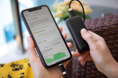 Alanya, Türkiye - 6 Haziran 2020: Powerbank RavPower ve iPhone 11 uygulamalı kadın el ele tutuşması ekranda Batarya