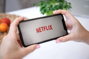 Alanya, Türkiye - 3 Temmuz 2020: Netflix uygulaması ile iPhone 11 'i tutan kadın ekranda yayın medyası ve video sağlıyor.