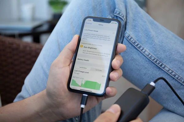 Alanya, Türkiye - 9 Mayıs 2020: Powerbank RavPower ve iPhone 11 'i ekranda uygulama pili ile elinde tutan adam