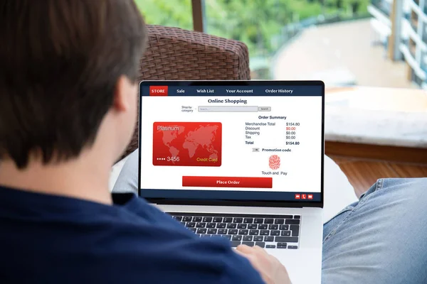 自宅のパソコンでオンラインショッピングをしている男が — ストック写真
