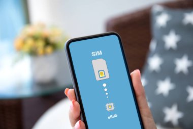 eSim 'de Sim kartının değiştirildiği bir kadın el telefonu.