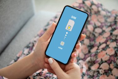 Çok renkli elbiseli kadın elleri eSi 'de Sim kart değiştirici ile telefonu tut