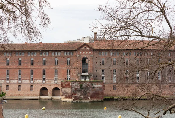 View of an old brick building on the banks of the Garonne river in Toulouse