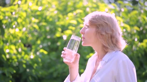 Een Vrouw Drinkt Water Uit Een Glas Vroege Ochtend Tegen — Stockvideo