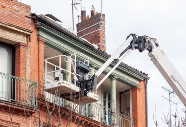 Eski bir evin duvarına dikilmiş bir vinç.