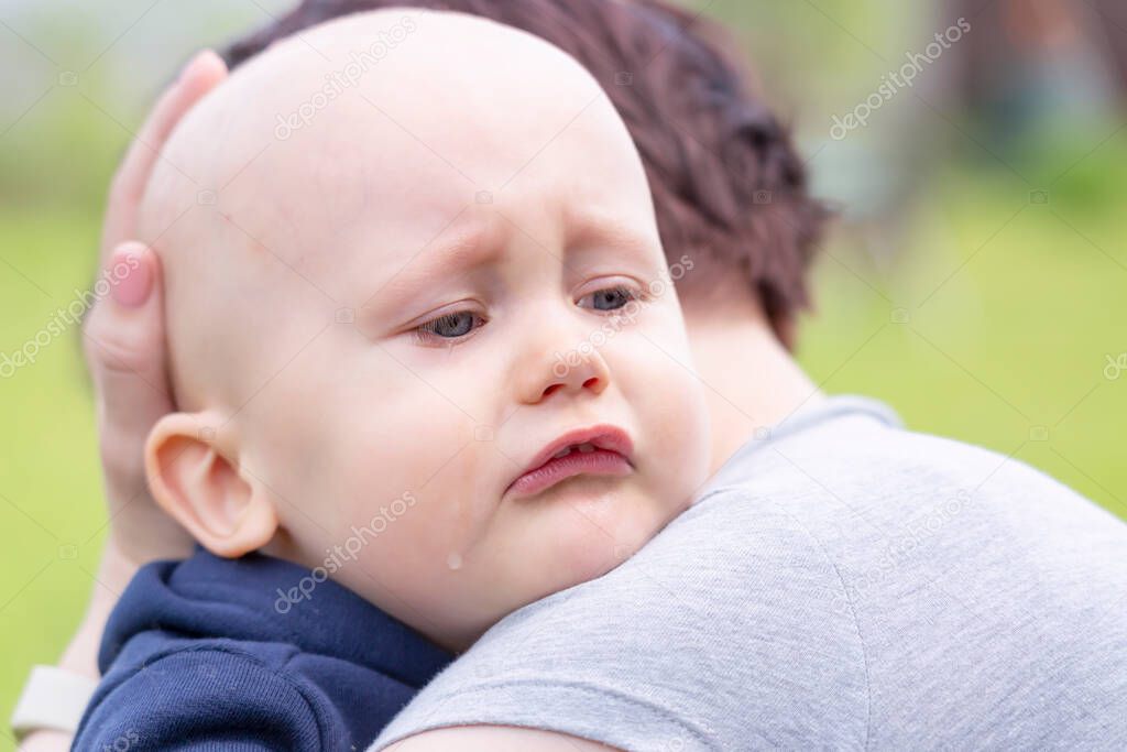 A mother comforts her crying little boy by holding him close and stroking his head