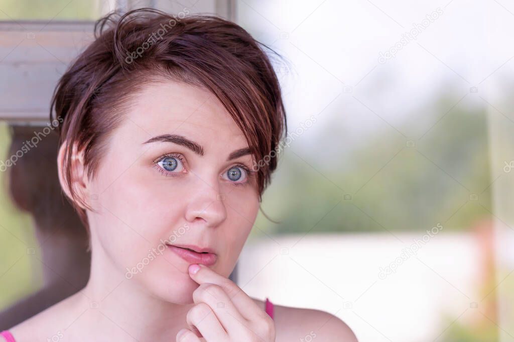 Portrait of a girl, thoughtfully touching her hand to her lips