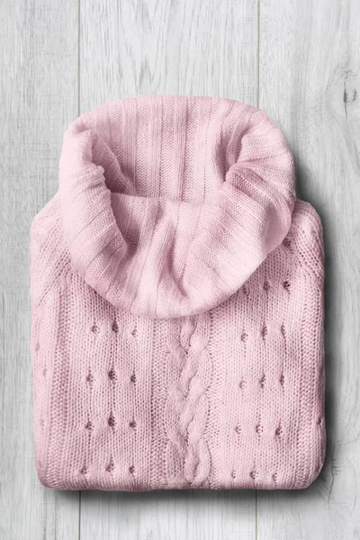 白い木製の背景にピンクのウールのセーターを折り — ストック写真