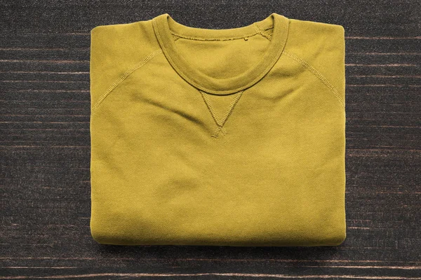 Składany Żółta Bluza Ciemnym Tle Drewnianych — Zdjęcie stockowe