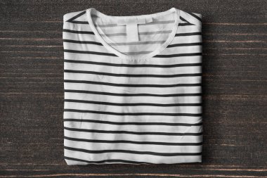 Çizgili gömlekli koyu kahverengi ahşap arka plan üzerinde katlanmış