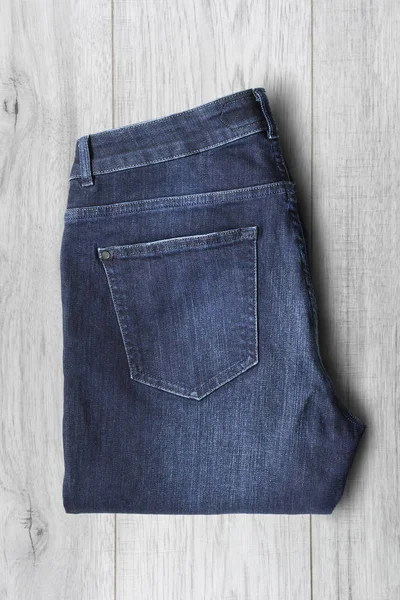 Calça Jeans Azul Dobrada Fundo Madeira Branca — Fotografia de Stock