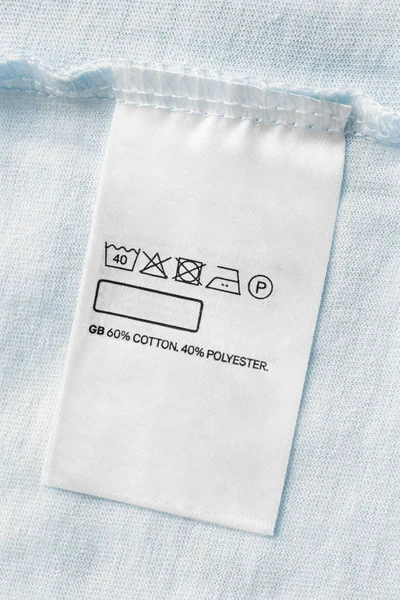 Care and composition clothes label on pastel blue textile background