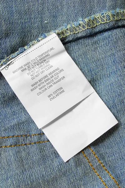 Composition Care Clothes Label Blue Denim Background Closeup — Stock Photo, Image