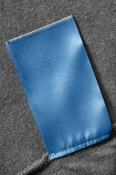 Lege Blauwe Kleding Label Zwart Textiel Achtergrond Closeup — Stockfoto