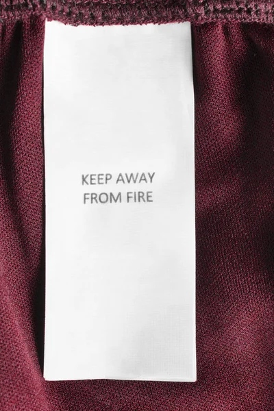 Этикетке Одежды Написано Держаться Подальше Огня Красном Текстильном Фоне — стоковое фото