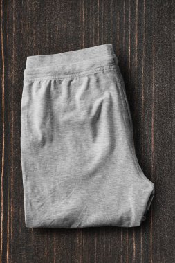 Gri spor pantolon koyu ahşap arka plan üzerinde katlanmış