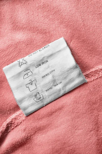 Zorg Kleding Label Roze Textiel Achtergrond Closeup — Stockfoto