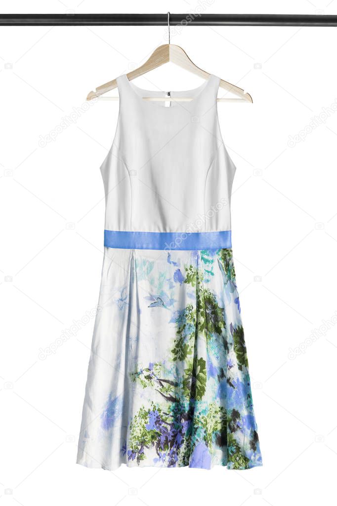 White silk dress with floral printed skirt hanging on wooden clothes rack isolated over white