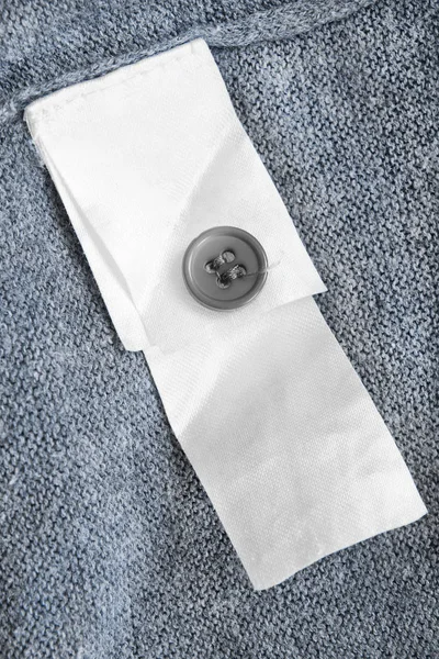 Button Blank White Clothes Label Blue Knitted Background Closeup — Stock Photo, Image