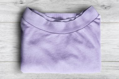 Mor kazak Beyaz ahşap arka plan üzerinde katlanmış