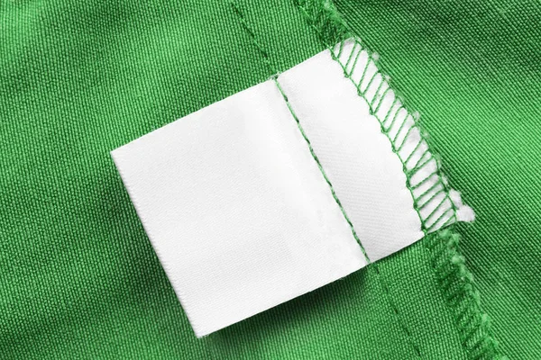 Lege Witte Kleren Label Groene Katoen Achtergrond Closeup — Stockfoto