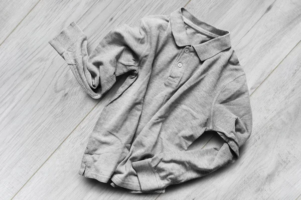 Grey cotton crumpled basic shirt on white wooden background