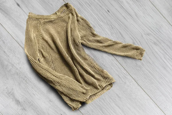 Смятый Золотой Вязаный Пуловер Белом Деревянном Фоне — стоковое фото