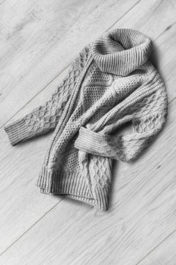 Beyaz ahşap zemin üzerinde buruşuk gri yün sıcak kazak