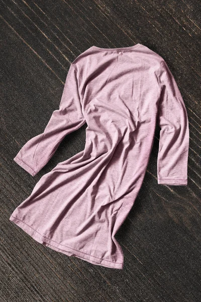 暗い茶色の木製の背景にくしゃくしゃにしたピンクのコットン ドレス — ストック写真