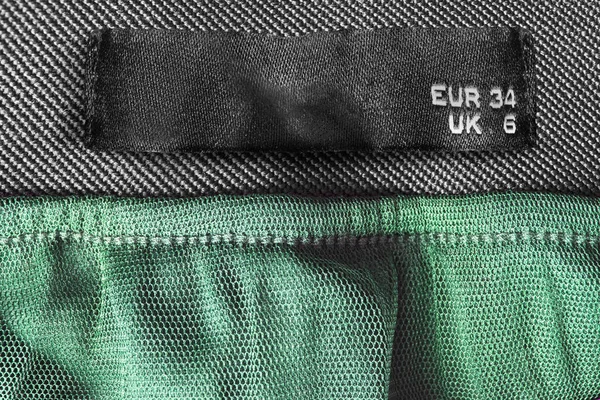 Etiqueta Ropa Tamaños Sobre Fondo Textil Negro Verde —  Fotos de Stock