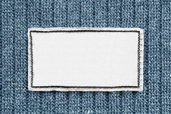 Štítek Bílý Prázdný Oblečení Modré Pletené Pozadí Closeup — Stock fotografie