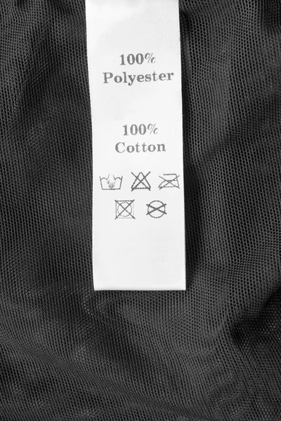 Fabric composition and care clothing label on black textile background