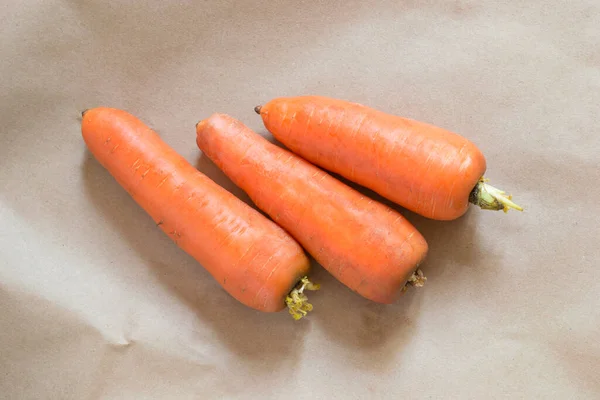 Tres Zanahorias Crudas Sobre Fondo Papel Artesanal Marrón —  Fotos de Stock