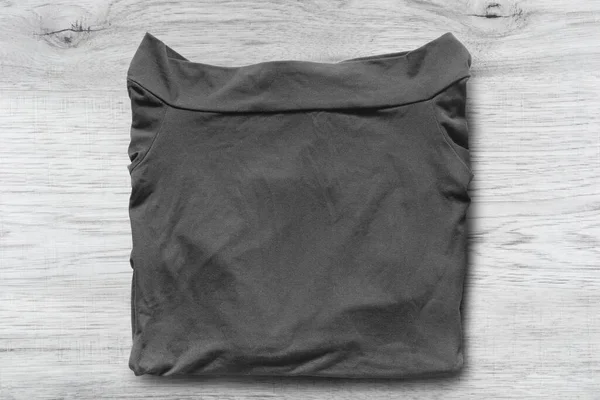Διπλωμένη Μαύρη Μπλούζα Λευκό Ξύλινο Φόντο — Φωτογραφία Αρχείου