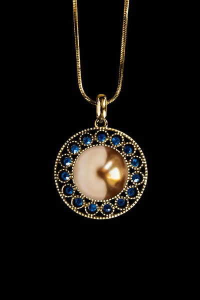 古色古香的金色珍珠挂件 蓝色的宝石挂在黑色背景的链子上 — 图库照片