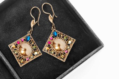 Pahalı altın küpeler ve mücevher kutusunda altın inciler.