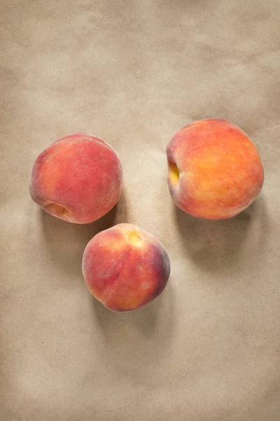 Three Fresh Red Peaches Craft Paper Background — Stock Photo, Image