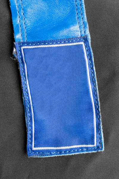 Blaues Bekleidungsetikett Auf Schwarzem Textilhintergrund Nahaufnahme — Stockfoto