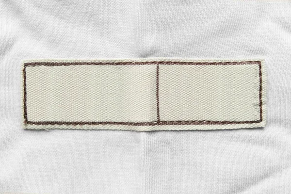 Etiqueta Vestuário Bege Branco Sobre Fundo Têxtil Branco — Fotografia de Stock