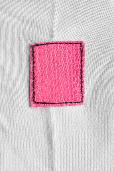 Blank pink textile patch on white textile background